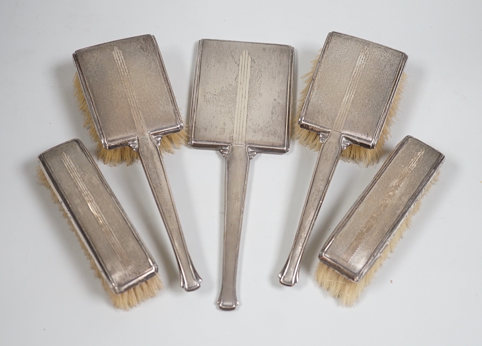 A 1930's Art Deco silver mounted five piece brush and mirror set, Birmingham, 1937.